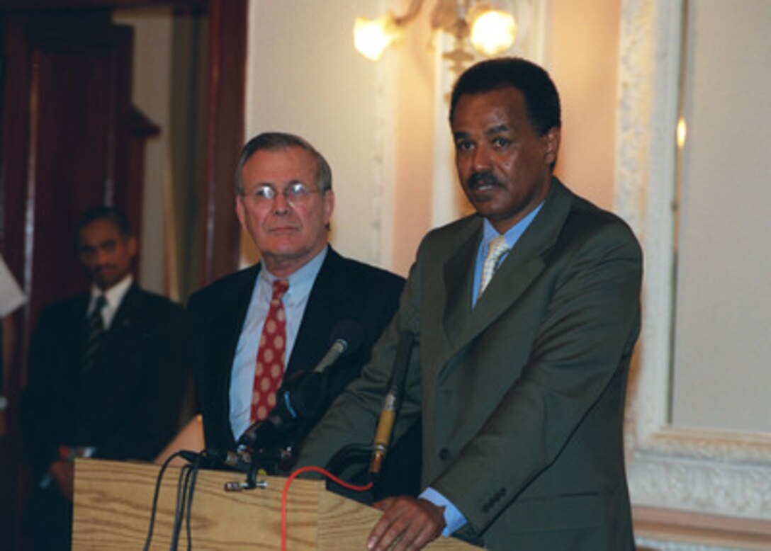 Secretary of Defense Donald H. Rumsfeld listens to President Isaias Afwerki respond to a reporter's question during a joint press briefing at Denden Club, Asmara, Eritrea, on Dec. 10, 2002. Rumsfeld traveled to Eritrea to meet with leaders concerning defense issues and the war on terrorism. 