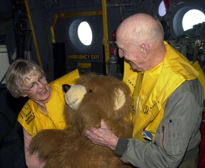 OVER THE PACIFIC OCEAN -- Retired Col. Gail Halvorsen and his wife, Lorraine, inspect a stuffed bear before it was dropped Dec. 21 during the 50th anniversary flights of Christmas Drop. For 50 years people at Andersen Air Force Base, Guam, have gathered Christmas gifts and supplies to be airdropped to Pacific islanders. A C-130 Hercules and crew from Yokota Air Base Japan, did the duty this year, delivering the goods to the islands of Anatahan, Agrihan, and Alamgan, which are north of Guam. Among the cargo dropped was rice, fishing gear, and machetes. Halvorsen is the famed "Candy Bomber" who dropped candy to the children of Berlin during the Berlin Airlift. (U.S. Air Force photo by Airman 1st Class Joshua Strang)