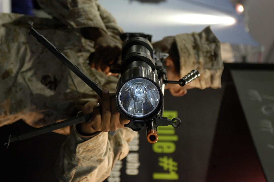 Lance Cpl. Matthew B. Evertt, personal adminstration, I Marine Expeditionary Force, tests the Night Hunter II, a rifle mountable flashlight at the Marine Corps Instillations West Expo, Jan. 18 -19. The NHII can be used to see objects 1200 meters away with white light and 800 meters away with infrared attachment. The light weighs four and a half pounds over half the weight of an M16-A2.
