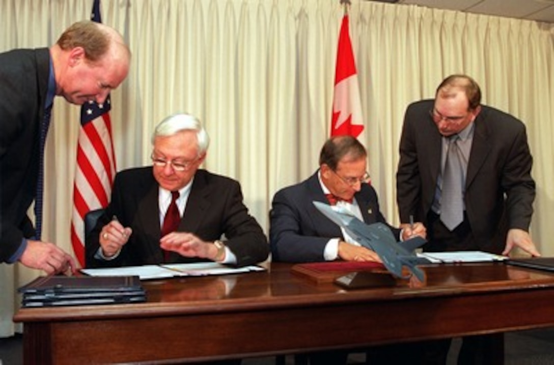 Under Secretary of Defense for Acquisition, Technology, and Logistics Edward C. "Pete" Aldridge, Jr. (seated left) and his Canadian counterpart Assistant Deputy Minister for Materiel Alan Williams (seated right) sign a memorandum of understanding at the Pentagon on Feb. 7, 2002. The memorandum commits Canada to participate in the joint strike fighter system development and demonstration phase. The joint strike fighter is the military's next generation, multi-role, strike aircraft designed to complement the Navy F/A-18 and the Air Force F-22 aircraft. The joint strike fighter program is the largest DoD acquisition program in history. 