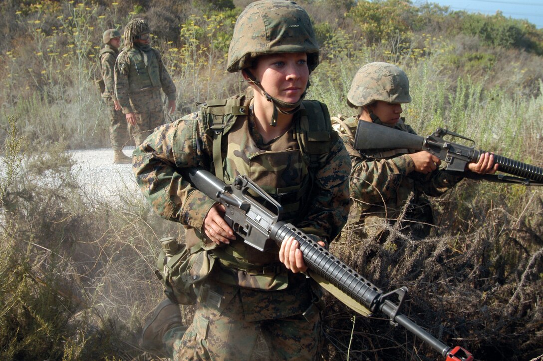 Marine Air Group - 39 Administration Marines Lance Cpl. Cori L. Bratley and Lance Cpl. Stephanie M. Chicoj rush into a bush by the 53 area. The excercise was part of the convoy on Day 2 of their commands training.
