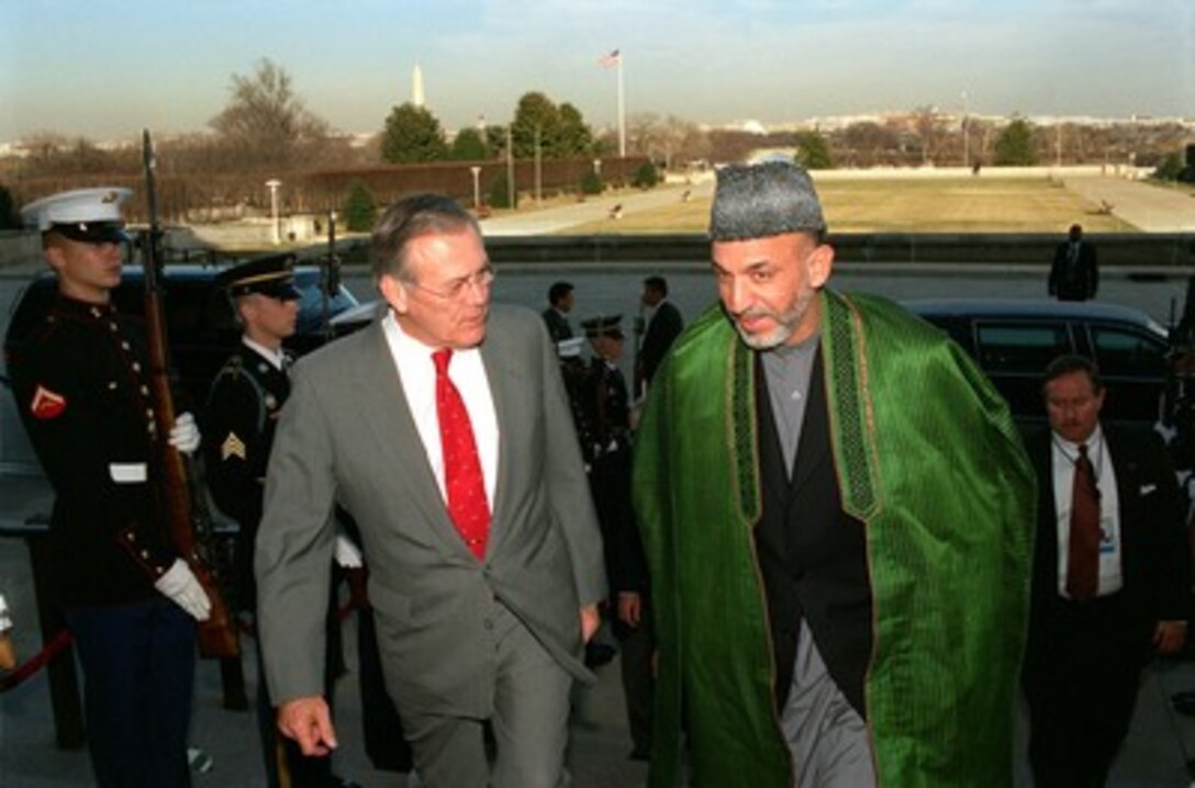Secretary of Defense Donald H. Rumsfeld (left) escorts Chairman of the Afghan Interim Administration Hamid Karzai (right) through an honor cordon and into the Pentagon on Jan. 28, 2002. Rumsfeld and Karzai will meet to discuss a broad range of bilateral security issues. 