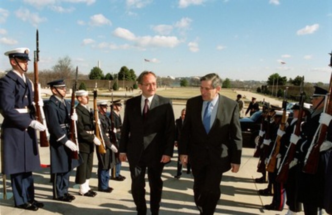 Chief, Federal Department of Defense Samuel Schmid (left), of Switzerland, is escorted through an honor cordon and into the Pentagon by Deputy Secretary of Defense Paul D. Wolfowitz (right) on Feb. 11, 2002. 