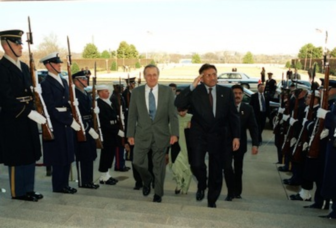 Secretary of Defense Donald H. Rumsfeld (left) escorts Pakistani President Pervez Musharraf (right) through an honor cordon and into the Pentagon on Feb. 13, 2002. The two leaders will meet to discuss the war on terrorism and defense issues of mutual interest. 