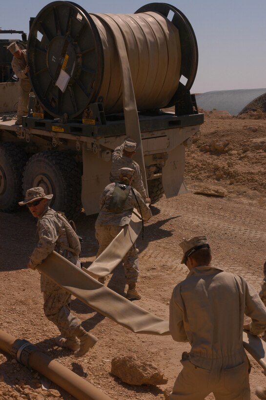 AL ASAD, Iraq (March 15, 2005) - Bulk fuel Marines from Combat Logistics Battalion 2 on roll new fuel line to replace older ones. The fuel Marines have been busy since there arrival Feb. 19 redesigning the air base's existing fuel farm.