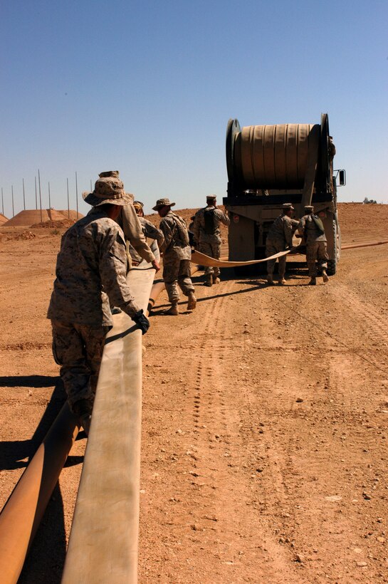 AL ASAD, Iraq (March 15, 2005) - Bulk fuel Marines from Combat Logistics Battalion 2 on roll new fuel line to replace older ones. The fuel Marines have been busy since there arrival Feb. 19 redesigning the air base's existing fuel farm.