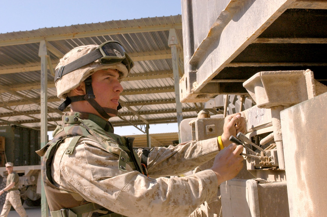 AL ASAD, Iraq (March 15, 2005) - Lance Cpl. Jared J. Drucker, logistics vehicle systems operator and native of Randolph, N.J., loads a case ban onto one of Transportation Company's seven-ton trucks. The Marines and sailors of CLB-2's Trans. Co. are responsible for bring food, water and supplies to remote operating posts throughout the Al Anbar province.