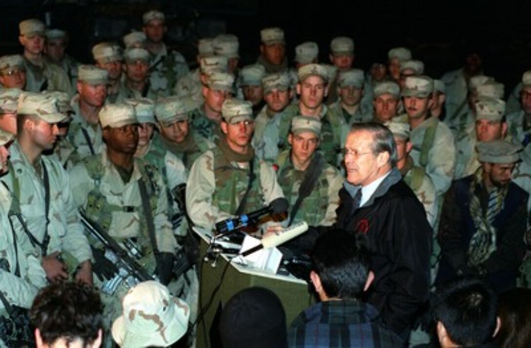 Secretary of Defense Donald H. Rumsfeld is surrounded with U.S. troops as he talks to them at Bagram Air Base, Afghanistan, on Dec. 16, 2001. The troops are deployed to Bagram in support of Operation Enduring Freedom. Rumsfeld is in Afghanistan to talk to the troops and to meet with the newly appointed Afghan leaders. 