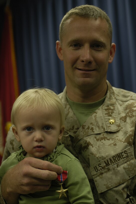 Major Breven C. Parsons hugs his daughter, Helena, after receiving the Bronze Star Medal at Camp Pendleton, Calif., Jan. 6. Parsons received the honor for his actions in support of Operation Iraqi Freedom as the staff judge advocate for 1st Battalion, 5th Marine Regiment last year.