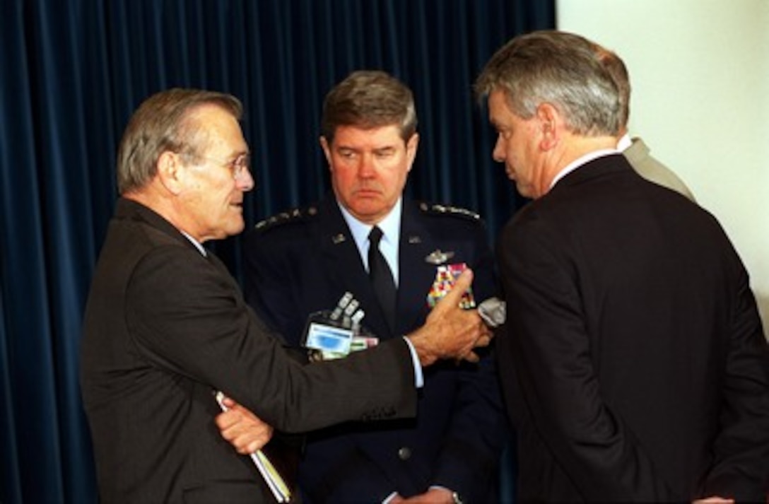 Secretary of Defense Donald H. Rumsfeld (left), Commander in Chief European Command, and Supreme Allied Commander Europe Gen. Joseph W. Ralston (center), U.S. Air Force, and French Minister of Defense Alain Richard (right) conduct informal talks between meetings at NATO Headquarters in Brussels, Belgium, on Dec. 18, 2001. 