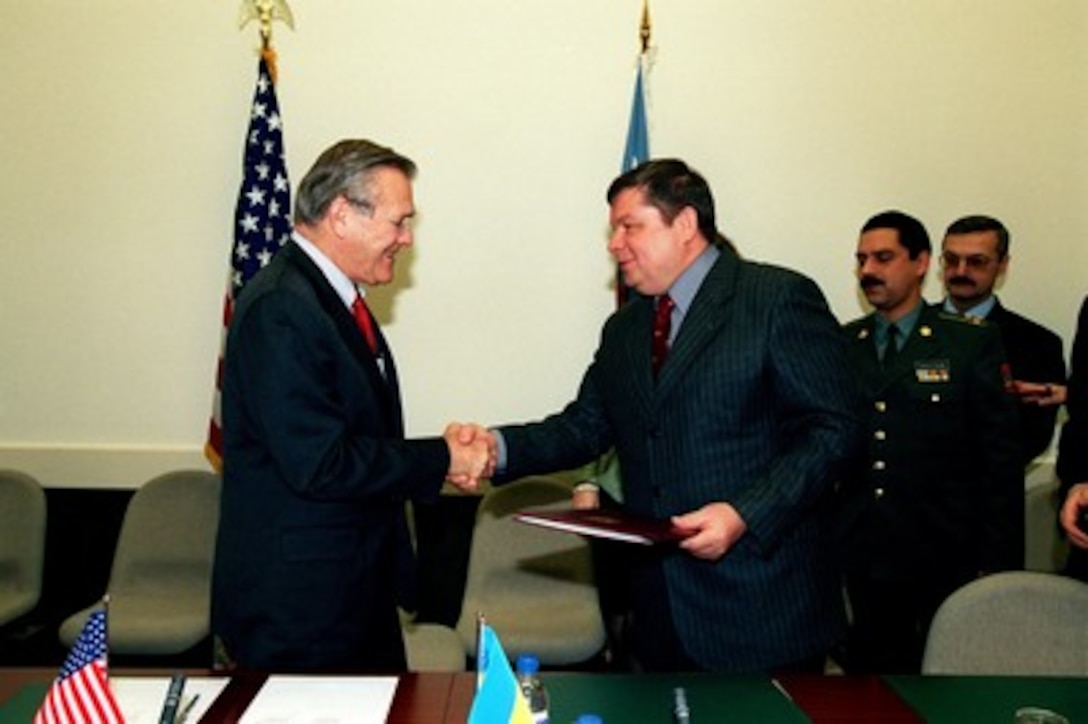 Secretary of Defense Donald H. Rumsfeld shakes hands with Ukrainian Minister of Defense Gen. Volodymyr Shkidchenko after signing a Plan of Cooperation between the Department of Defense of the U.S. and the Ministry of Defense of Ukraine at NATO Headquarters in Brussels, Belgium, on Dec. 19, 2001. The two leaders are in Brussels for the semi-annual NATO Defense Ministerial. 