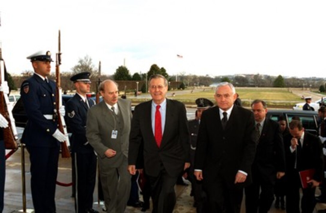 Secretary of Defense Donald H. Rumsfeld (center) escorts Prime Minister Leszek Miller (right), of Poland, into the Pentagon on Jan. 11, 2002. The two leaders will meet to discuss defense issues of mutual interest. 