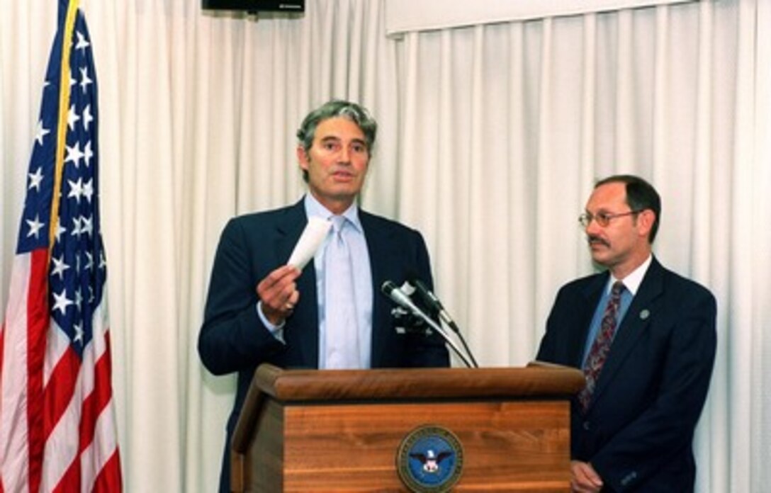 Actor Michael Nouri (left) presents a donation to military and civilian relief societies in commemoration of the victims of the Sept. 11th attack on the Pentagon on June 26, 2002. Under Secretary of Defense (Comptroller) Dov S. Zakheim received the donation at a Pentagon ceremony. The donation of approximately $181,000 represents funds collected following presentation of a traveling production of "South Pacific," in which Nouri had the leading role. 