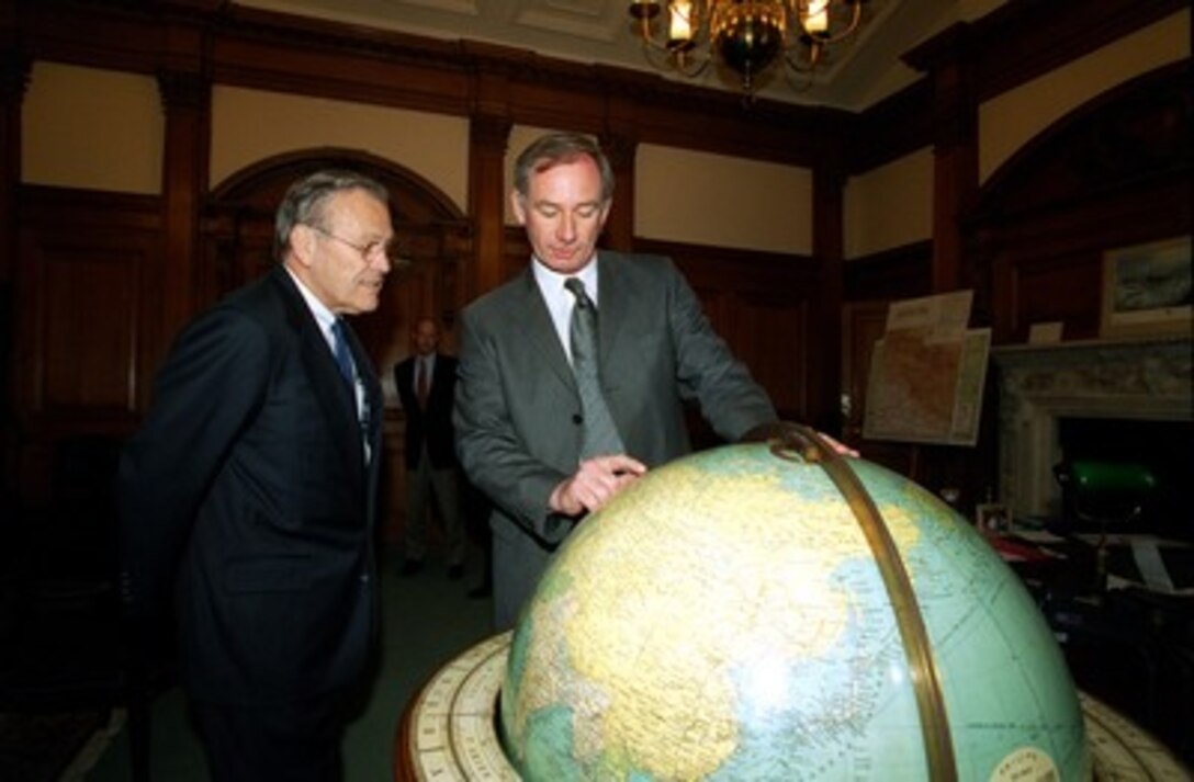 Secretary of State for Defence Geoffrey Hoon (right) points out a spot on the globe to Secretary of Defense Donald H. Rumsfeld in Hoon's office in the Old War Office Building, London, England, on June 5, 2002. Hoon and Rumsfeld are meeting to discuss defense issues of mutual interest. Rumsfeld is beginning a 10-day tour of nine countries to meet with senior leaders and to visit with U.S. troops deployed abroad. 