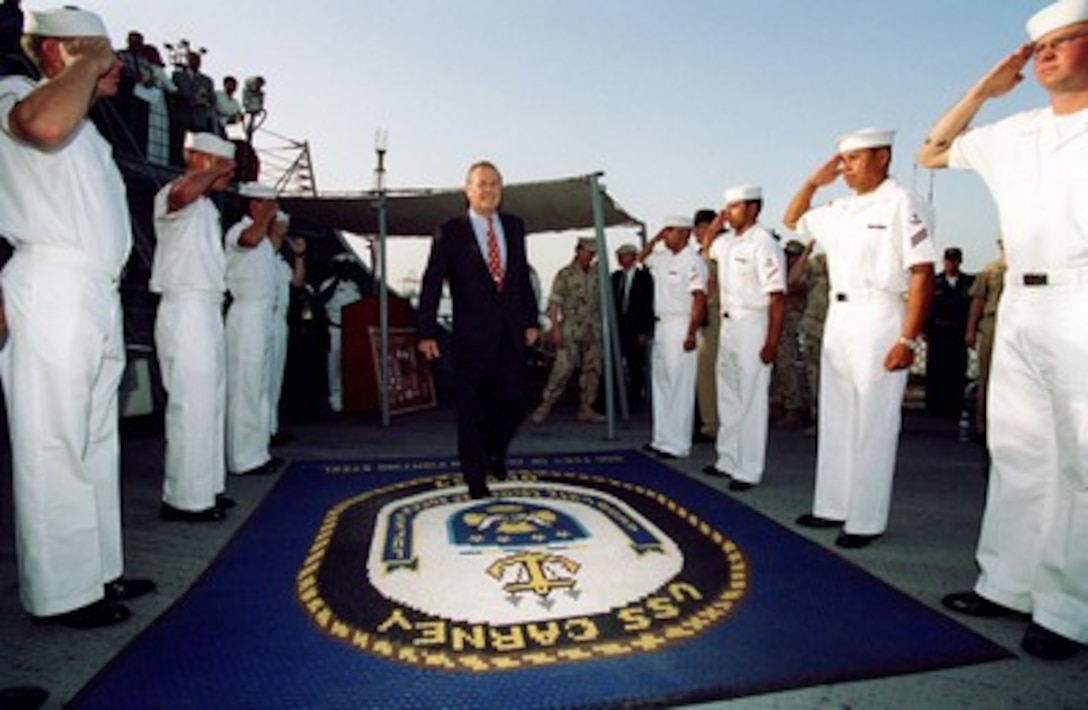Secretary of Defense Donald H. Rumsfeld walks through the sideboys as he is piped aboard the USS Carney (DDG 64) while in port in Bahrain on June 10, 2002. Rumsfeld is on a 10-day tour of nine countries to meet with senior leaders and to visit with U.S. troops deployed abroad. 
