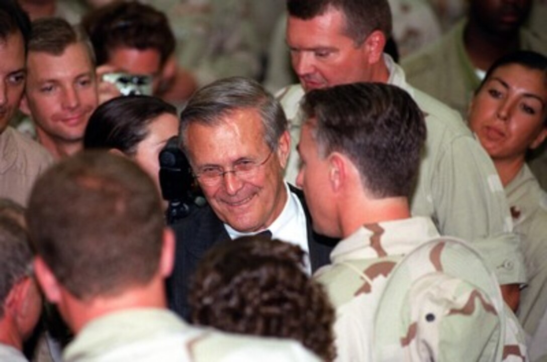 Secretary of Defense Donald H. Rumsfeld mingles with U.S. troops during his visit at Al-Udeid Air Base, Qatar, on June 11, 2002. Rumsfeld is on a 10-day tour of nine countries to meet with senior leaders and to visit with U.S. troops deployed abroad. 