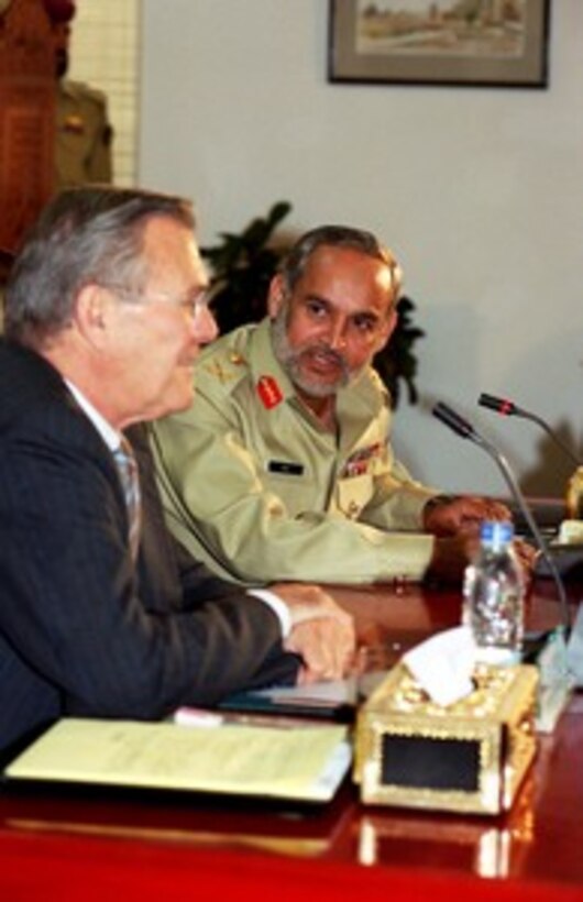 Chairman Joint Chiefs of Staff Committee Gen. Muhammad Aziz Khan (right) begins a bilateral meeting with Secretary of Defense Donald H. Rumsfeld (left) by welcoming him to Islamabad, Pakistan, on June 13, 2002. Rumsfeld is on a 10-day tour of nine countries to meet with senior leaders and to visit with U.S. troops deployed abroad. 