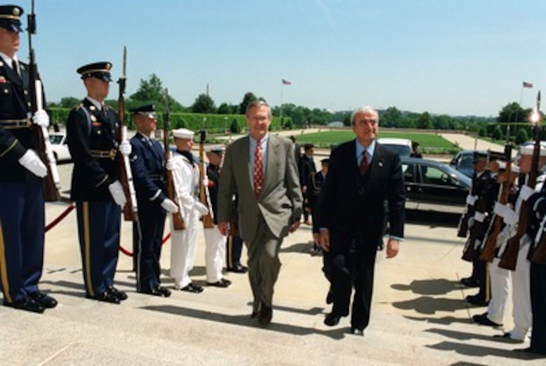 Secretary of Defense Donald H. Rumsfeld (left) escorts Italian Minister of Defense Antonio Martino through an honor cordon and into the Pentagon on May 10, 2002. Rumsfeld and Martino will meet to discuss defense issues of mutual interest. 