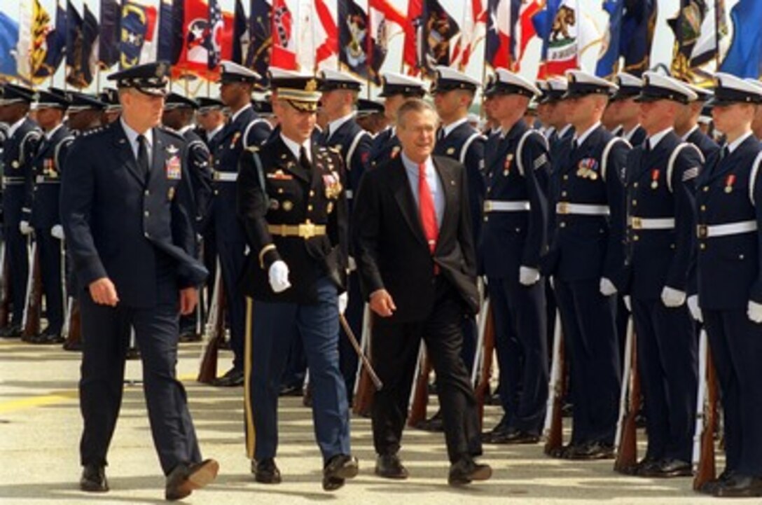 Secretary of Defense Donald H. Rumsfeld (right) and Chairman of the Joint Chiefs of Staff Gen. Richard B. Myers (left), U.S. Air Force, are escorted by Commander of Troops Col. James F. Laufenberg, U.S. Army, as they inspect the joint services honor guard during the opening ceremonies of the Joint Service Open House at Andrews Air Forces Base, Md., on May 17, 2002. The two-day open house features precision flight demonstrations, free-fall formation parachuting and displays of a wide variety of military equipment. 