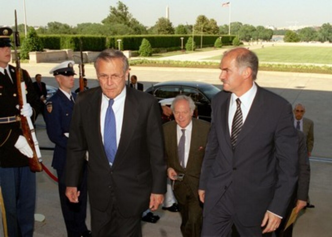 Greek Foreign Minister Yeoryios Papandreou (right) is escorted by Secretary of Defense Donald H. Rumsfeld (left) into the Pentagon on May 23, 2002. Papandreou and Greek Ambassador to the United States Alexandros Philon (center) will meet with senior Department of Defense officials to discuss a range of bilateral security issues. 