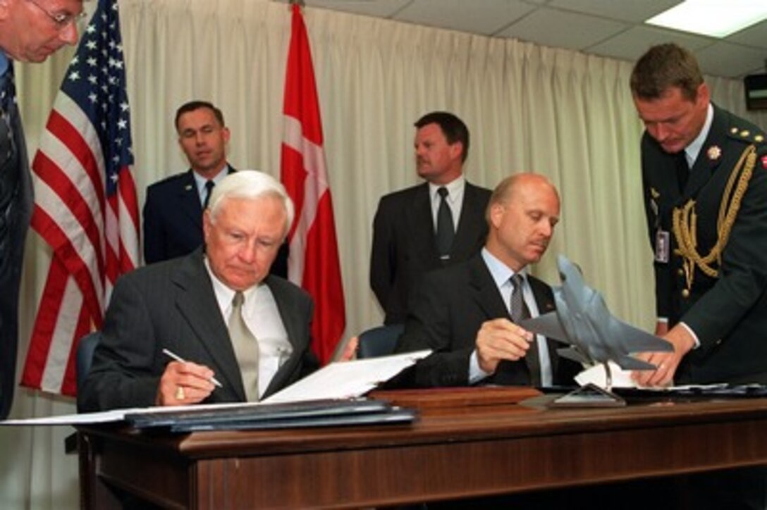 Under Secretary of Defense for Acquisition, Technology, and Logistics Edward C. "Pete" Aldridge (seated left) and his Danish counterpart, Deputy Permanent Secretary of State for Defense and National Armaments Director Jorgen Hansen-Nord (seated right), sign a memorandum of understanding in the Pentagon on May 28, 2002. The memorandum commits Denmark to participate in the joint strike fighter system development and demonstration phase. The joint strike fighter is the military's next generation, multi-role, strike aircraft designed to complement the Navy F/A-18 and the Air Force F-22 aircraft. The joint strike fighter program is the largest DoD acquisition program in history. 