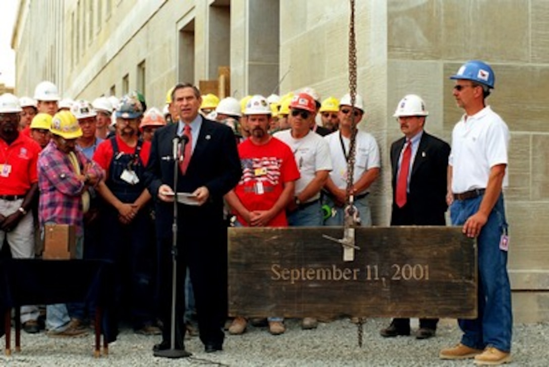 Deputy Secretary of Defense Paul Wolfowitz (center) addresses the audience during the Dedication Capsule ceremony at the Pentagon on June 11, 2002. Pentagon Renovation Program Manager Walker Lee Evey (second from right) will insert the capsule in the wall of the building where it will be covered by the last piece of limestone, completing the Pentagon's western facade damaged by the Sept. 11th terrorist attack. The engraved limestone, charred and discolored by the impact and resultant fire, is one of the original stones installed during construction of the Pentagon. 