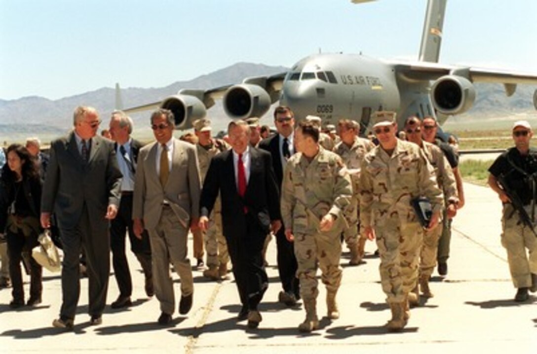 Secretary of Defense Donald H. Rumsfeld (center) arrives at Bagram Air Base, Afghanistan, on April 27, 2002. Rumsfeld is visiting Bagram to be briefed by Commanding General of the Coalition Joint Task Force, Maj. Gen. Franklin L. "Buster" Hagenback, U.S. Army, (2nd from right). Accompanying Rumsfeld are U.S. Ambassador to Afghanistan Robert Finn (left), Presidential Special Envoy to Afghanistan Zalmay Khalilzad (2nd from left) and Vice Adm. Edmund Giambastiani (right), U.S. Navy, senior military assistant to Rumsfeld. 