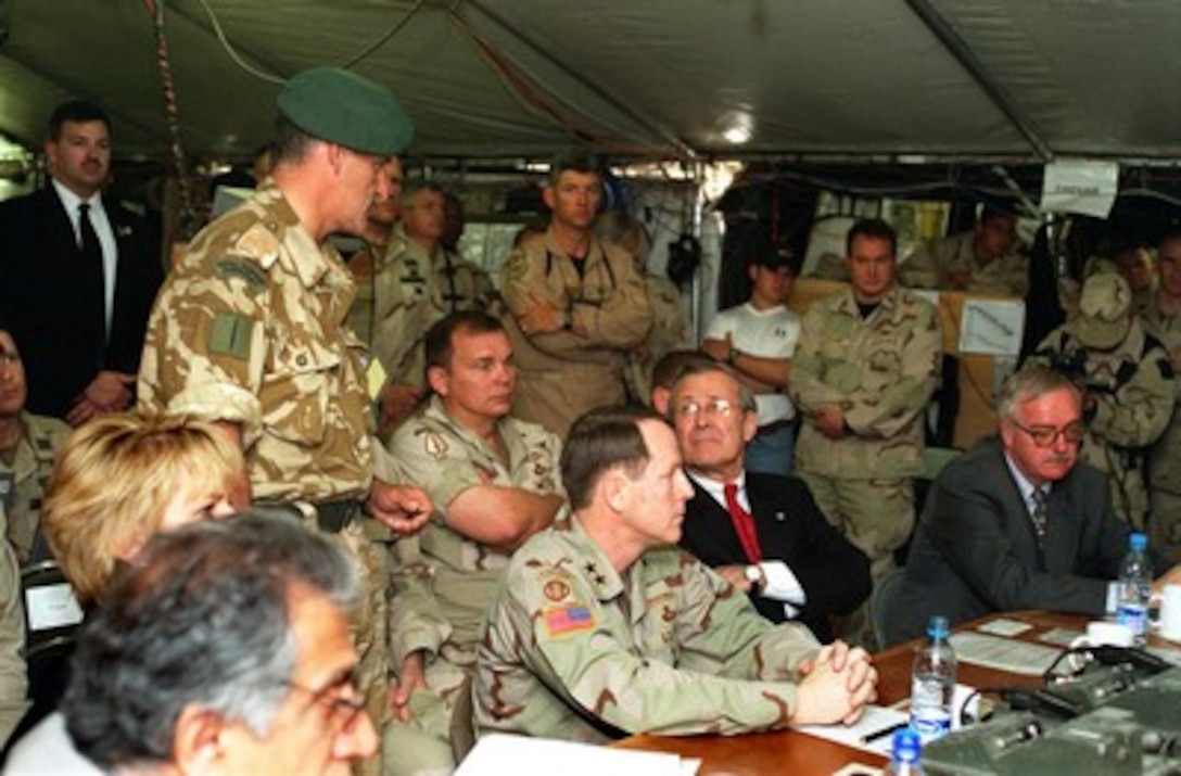 Secretary of Defense Donald H. Rumsfeld (seated center) listens as a commando officer of Her Majesty's Royal Marines (United Kingdom) tells of his units' experiences in fighting Taliban and al-Qaeda forces in the mountains of Afghanistan during a briefing at Bagram Air Base, Afghanistan, on April 27, 2002. Rumsfeld is visiting Bagram to be briefed on the latest combat operations in Afghanistan by Commanding General of the Coalition Joint Task Force, Maj. Gen. Franklin L. "Buster" Hagenback (seated left), U.S. Army. 