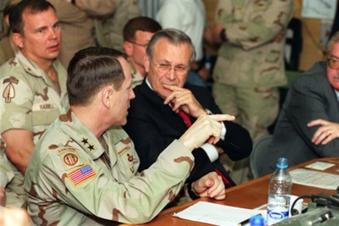 Maj. Gen. Franklin L. "Buster" Hagenback (left), U.S. Army, briefs Secretary of Defense Donald H. Rumsfeld on the latest combat operations in Afghanistan at Bagram Air Base, Afghanistan, on April 27, 2002. Rumsfeld is visiting Bagram for briefings on the war on terrorism and to meet coalition troops deployed there. Hagenback is the commanding general, Coalition Joint Task Force. 
