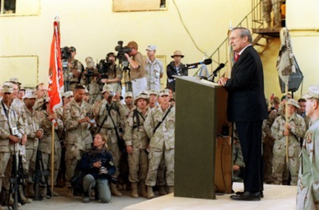Secretary of Defense Donald H. Rumsfeld addresses members of the Coalition Joint Task Force assembled in a hangar at Bagram Air Base, Afghanistan, on April 27, 2002. Rumsfeld is visiting Bagram to be briefed on the latest combat operations in Afghanistan and to meet coalition troops deployed there. 