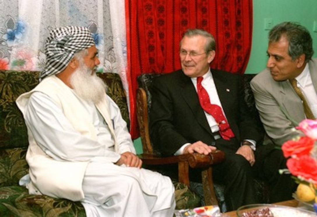 Secretary of Defense Donald Rumsfeld (center) meets with Ismail Khan (left), in Herat, Afghanistan, on April 27, 2002. Khan is one of the most powerful regional leaders in Afghanistan and his support is crucial to the new national government. Presidential Special Envoy to Afghanistan Zalmay Khalilzad (right) joined Rumsfeld and Khan in the talks. 