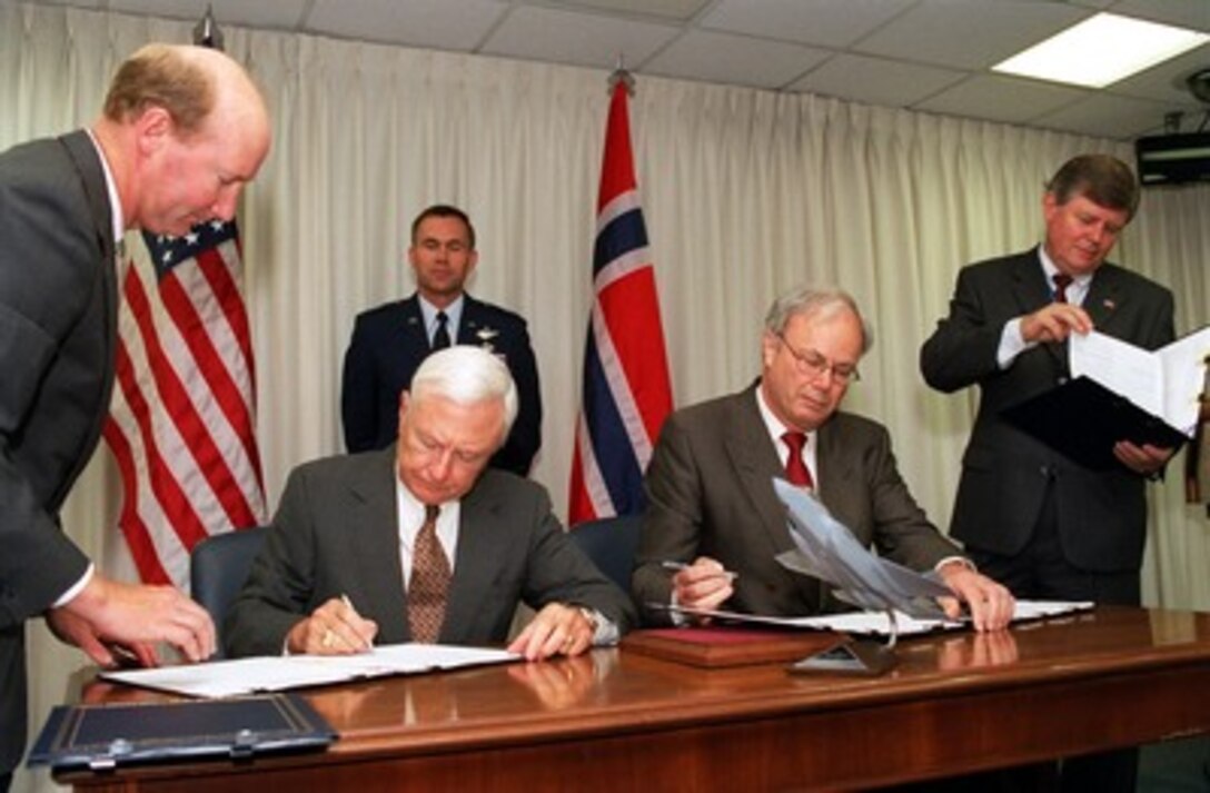 Under Secretary of Defense for Acquisition, Technology, and Logistics Edward C. "Pete" Aldridge (seated left) and Norwegian National Armaments Director Leif Lindback (seated right) sign a memorandum of understanding in the Pentagon on June 20, 2002. The memorandum commits Norway to participate in the Joint Strike Fighter system development and demonstration phase. The Joint Strike Fighter is the military's next generation, multi-role, strike aircraft designed to complement the Navy F/A-18 and the Air Force F-22 aircraft. The Joint Strike Fighter program is the largest DoD acquisition program in history. 