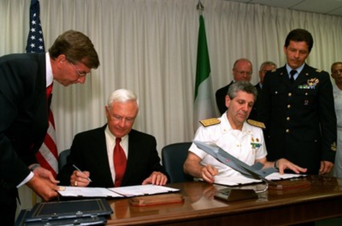 Under Secretary of Defense for Acquisition, Technology, and Logistics Edward C. "Pete" Aldridge (seated left) and Italian Secretary General of Defense and National Armaments Director Adm. Giampaolo Di Paola (seated right) sign a memorandum of understanding in the Pentagon on June 24, 2002. The memorandum commits Italy to participate in the Joint Strike Fighter system development and demonstration phase. The Joint Strike Fighter is the military's next generation, multi-role, strike aircraft designed to complement the Navy F/A-18 and the Air Force F-22 aircraft. The Joint Strike Fighter program is the largest DoD acquisition program in history. 