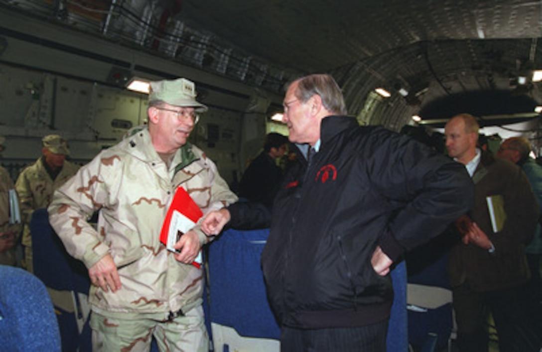 Vice Adm. Edmund Giambastiani, U.S. Navy, speaks to Secretary of Defense Donald H. Rumsfeld aboard a C-17 aircraft enroute to Central Asia on Dec. 16, 2001. 