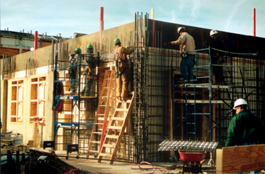 Construction workers erect a network of steel reinforcing rods inside a formwork in which concrete will be poured to create an inside wall of the D-ring of the Pentagon on Feb. 12, 2002. Crews are working nearly around-the-clock as they pour concrete for floors and walls to replace those damaged in the Sept. 11, 2001, terrorist attack on the building. 