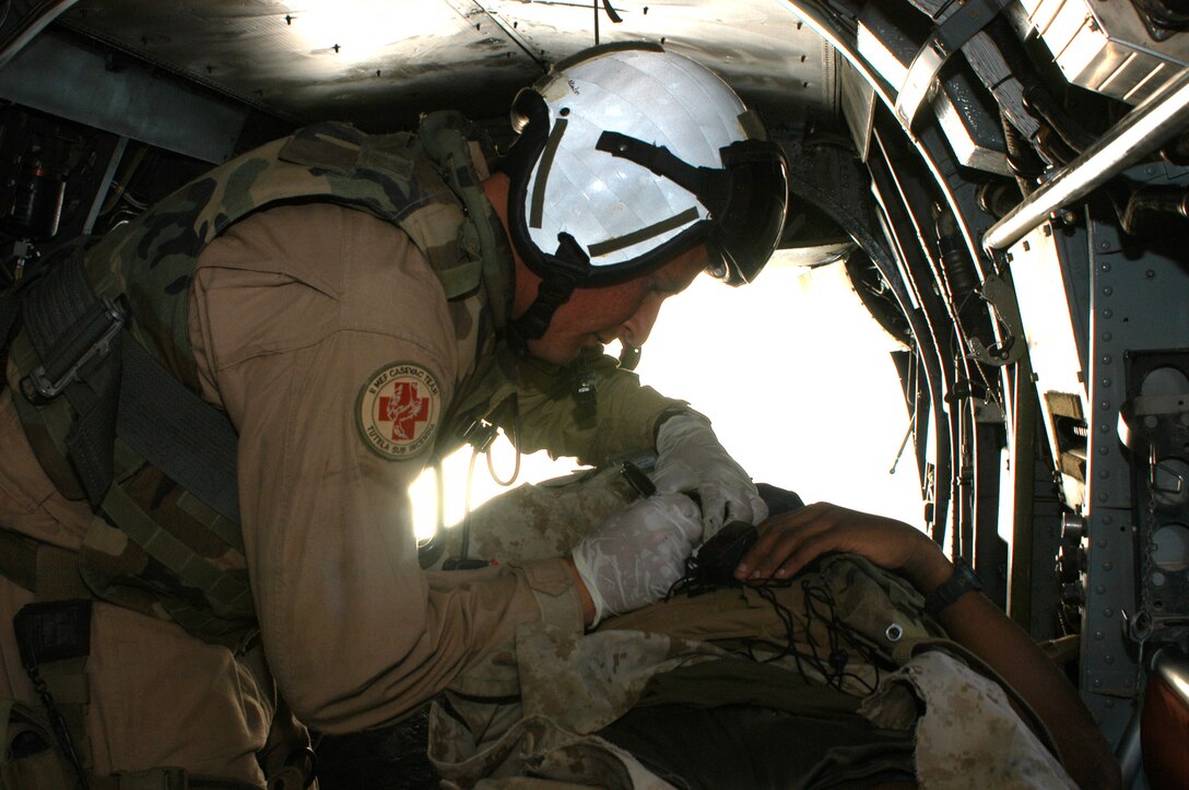 AL TAQADDUM, Iraq (March 29, 2005) - Petty Officer 3rd Class Aaron T. Newton, CASEVAC corpsman and native of San Diego, asses and treats a wounded Marine. Newton is a member of the 2nd Marine Expeditionary Force (Forward) causality evacuation team. Along with his fellow corpsmen, Newton is responsible for flying into hazardous areas to extract wounded Marines, soldiers and civilians.