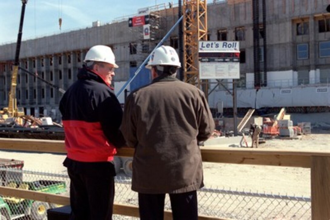 Secretary of Defense Donald H. Rumsfeld (left) receives an update on the status of the Pentagon reconstruction from project manager Walker Lee Evey (right) on March 11, 2002. Rumsfeld marked the 6th month anniversary of the terrorist attack on the Pentagon by visiting the site and speaking to the construction workers who are working nearly around the clock to finish the reconstruction by Sept. 11, 2002. 