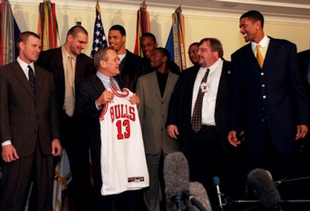 Secretary of Defense Donald H. Rumsfeld accepts a personalized team jersey from members of the National Basketball Association's Chicago Bulls in the Pentagon on March 4, 2002. Rumsfeld, a native son of Chicago, said the number 13 was very appropriate for him as he served between 1975 and 1977 as the nation's 13th secretary of defense and is currently serving as the 21st defense secretary. 