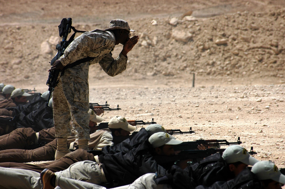 AL ASAD, Iraq (April 8, 2005) - Cpl. Michael A. Morton, border patrol instructor and native of Brownville Junction, Maine, helps an Iraqi Border Patrolman load a magazine during marksmanship training here. Morton and his fellow instructors trained 45 patrolmen, who graduated the three-week course April 9.