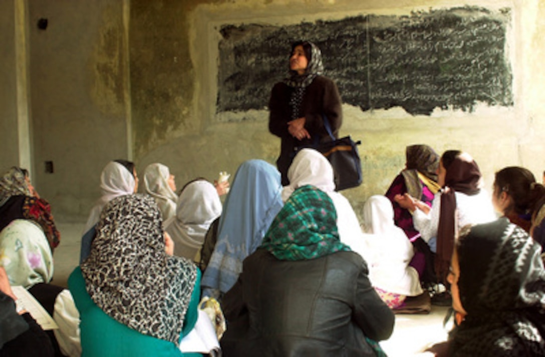 An Afghan woman teaches a class of girls in the Rukhshana School on March 11, 2002. Women are returning to teach and girls are now openly attending the school that was nearly destroyed during the Afghan civil war. The Rukhshana School will become the first Coalition Joint Civil Military Operations Task Force project funded in Kabul, Afghanistan. The Freedom Construction Company, an Afghan company, was contracted to remove the war debris in preparation for rebuilding the school. 