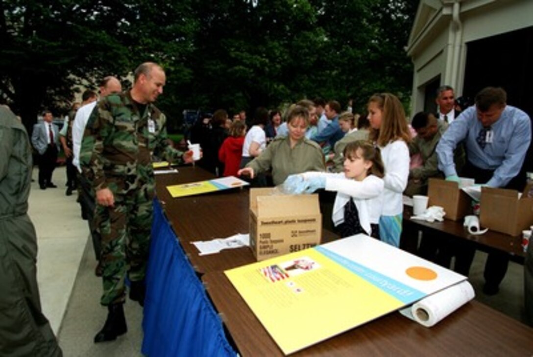 Air Force Chief Master Sgt. Nelson receives a cup of Stars and Stripes ice cream in the center courtyard of the Pentagon on April 29, 2002. The Gifford's Ice Cream Co., a family-owned business from Skowhegan, Maine brought 12 tons of the special red, white and blue ice cream to the nation's capital. 