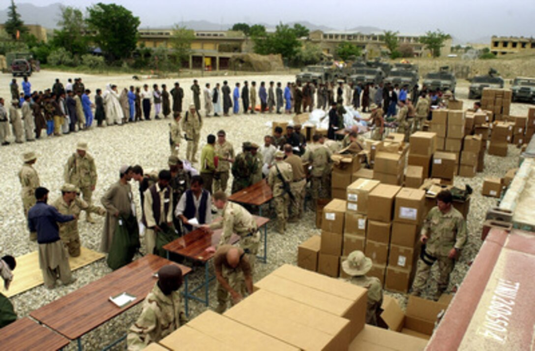 New recruits of the Afghan National Army line up to receive an issue of new uniforms and equipment by U.S. Army Special Forces soldiers at the Afghan National Army training site in Kabul, Afghanistan, on May 14, 2002. Approximately 150 U.S. Special Forces soldiers are deployed to Kabul to equip and train recruits of the new Afghan National Army in training cycles of approximately 10 weeks in duration. The training will emphasize basic soldier skills at the beginning of each training cycle and then progress to more complex tasks as skills are mastered. Collective training at the squad, platoon, company and battalion level will follow individual training. 