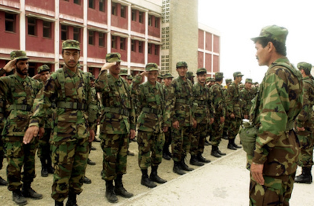 New recruits of the Afghan National Army practice saluting in their new uniforms at the Afghan National Army training site in Kabul, Afghanistan, on May 14, 2002. Approximately 150 U.S. Special Forces soldiers are deployed to Kabul to equip and train recruits of the new Afghan National Army in training cycles of approximately 10 weeks in duration. The training will emphasize basic soldier skills at the beginning of each training cycle and then progress to more complex tasks as skills are mastered. Collective training at the squad, platoon, company and battalion level will follow individual training. 