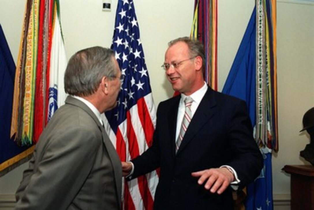 German Minister of Defense Rudolph Scharping (right) talks informally with Secretary of Defense Donald H. Rumsfeld at the beginning of their meeting in the Pentagon on April 23, 2002. The two defense leaders are meeting to discuss defense issues of mutual interest. 