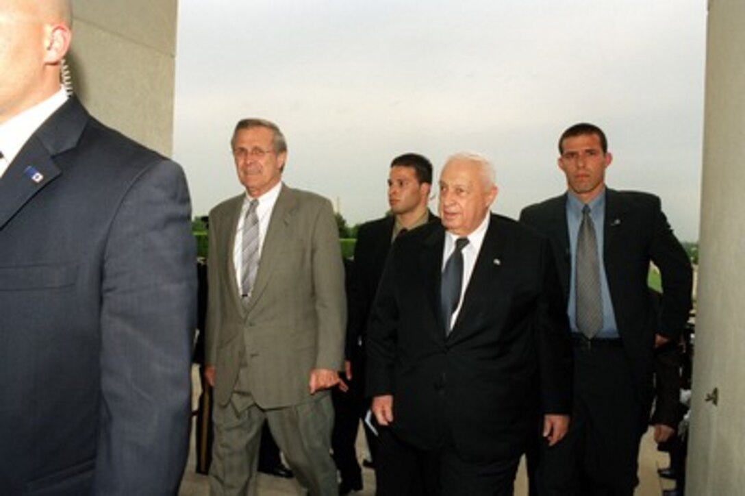 Secretary of Defense Donald H. Rumsfeld (left) escorts Israeli Prime Minister Ariel Sharon (2nd from right) into the Pentagon on May 6, 2002. Rumsfeld and Sharon will meet to discuss defense issues of mutual concern. 