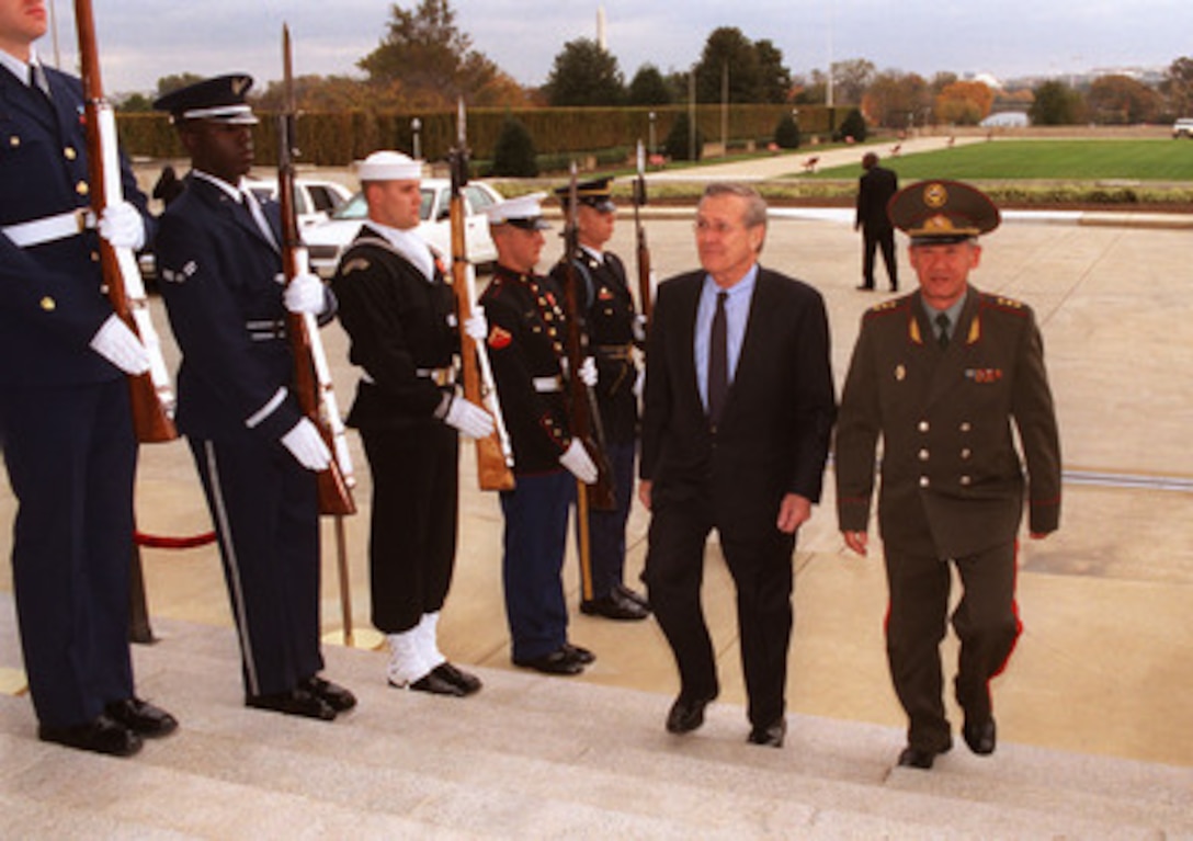 Secretary of Defense Donald H. Rumsfeld (left) escorts Minister of Defense Col. Gen. Esen Topoyev, of Kyrgyzstan, through an honor cordon and into the Pentagon on Nov. 7, 2002. The two defense leaders will meet to discuss a range of bilateral security issues. 