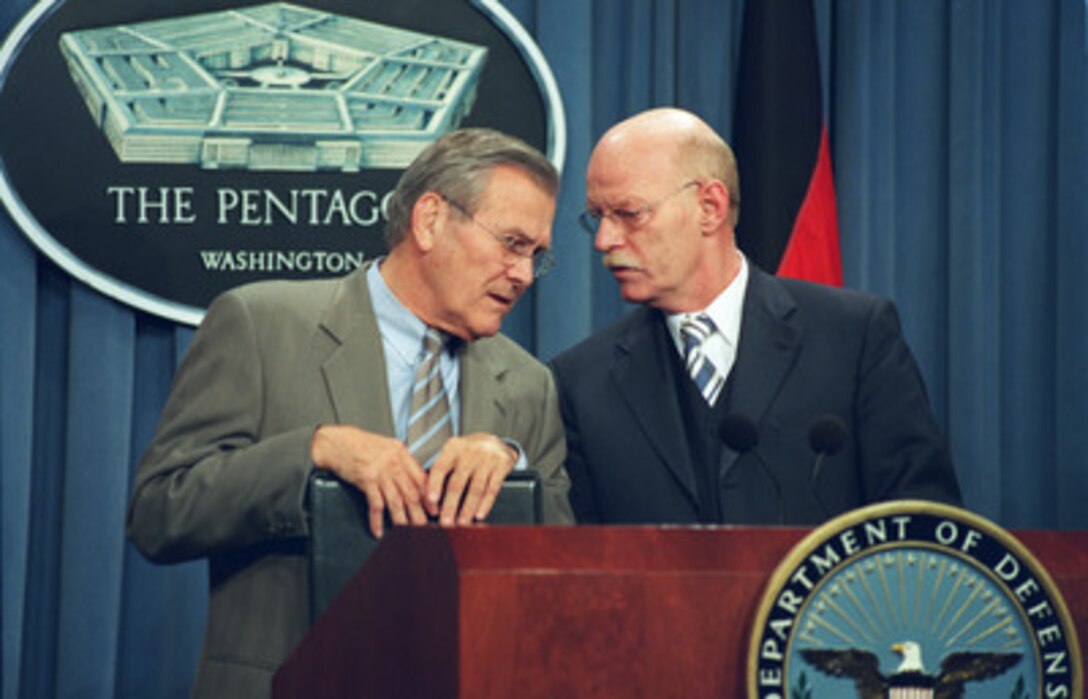 Secretary of Defense Donald H. Rumsfeld and German Minister of Defense Peter Struck exchange private comments during a joint press briefing in the Pentagon on Nov. 8, 2002. Rumsfeld and Struck met earlier to discuss defense issues of mutual interest. 
