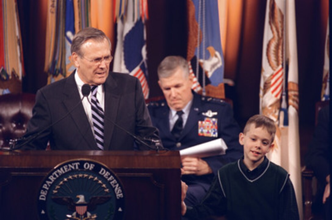 Secretary of Defense Donald H. Rumsfeld (left) opens the Pentagon Town Hall meeting on Nov. 12, 2002, by introducing 8-year-old David Bates (right), winner of the Army-sponsored Weekly Reader contest for his essay "My American Value" on selfless service. Chairman of the Joint Chiefs of Staff Gen. Richard B. Myers (center), U.S. Air Force, joined Rumsfeld in responding to questions from military members and civilian employees of the Department of Defense. 