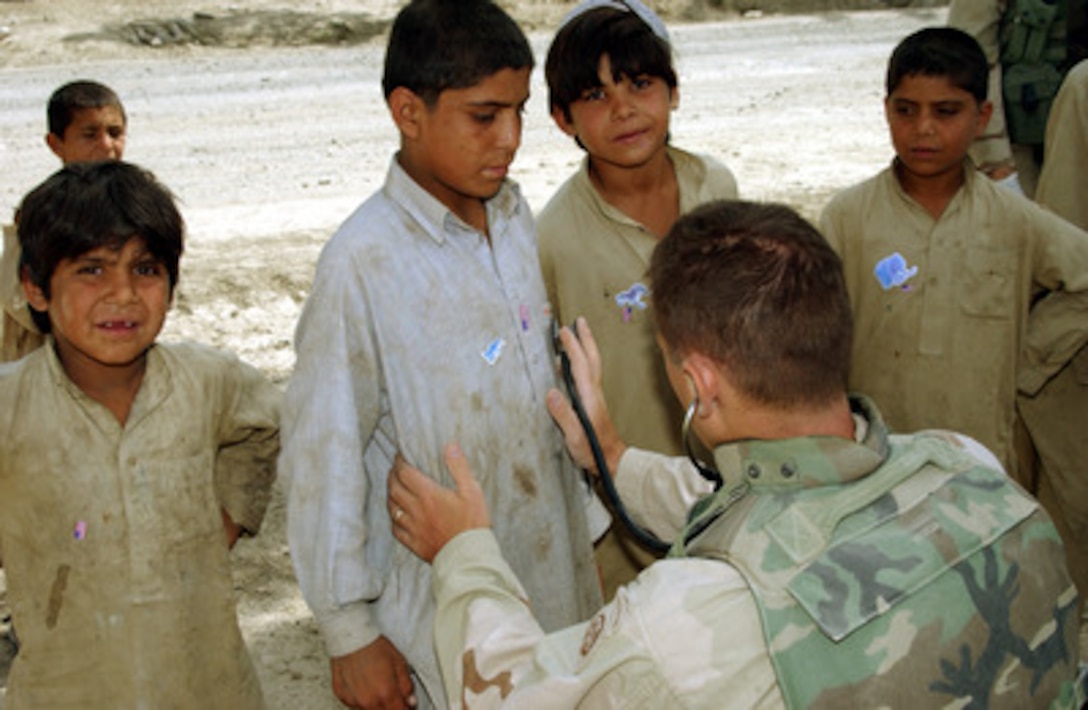 A soldier listens through a stethoscope as he examines an Afghan child in the village outside Camp Salerno near Khowst, Afghanistan, on Sept. 26, 2002. Soldiers of the 82nd Forward Support Battalion and 3rd Battalion of the 505th Parachute Infantry Regiment of Fort Bragg, N.C., are providing free medical treatment as part of humanitarian assistance programs designed to help the people of Afghanistan. 