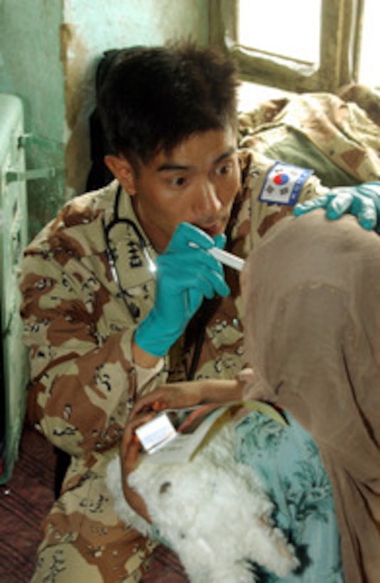 A Republic of Korea Army medic examines an Afghan child in the village of Sayed, Afghanistan, on Nov. 3, 2002. Medical and veterinary personnel from the U.S., Republic of Korea and Australian armed forces are providing free treatment as part of humanitarian assistance programs designed to help the people of Afghanistan. The coalition medical team saw over 900 Afghans for various ailments. 